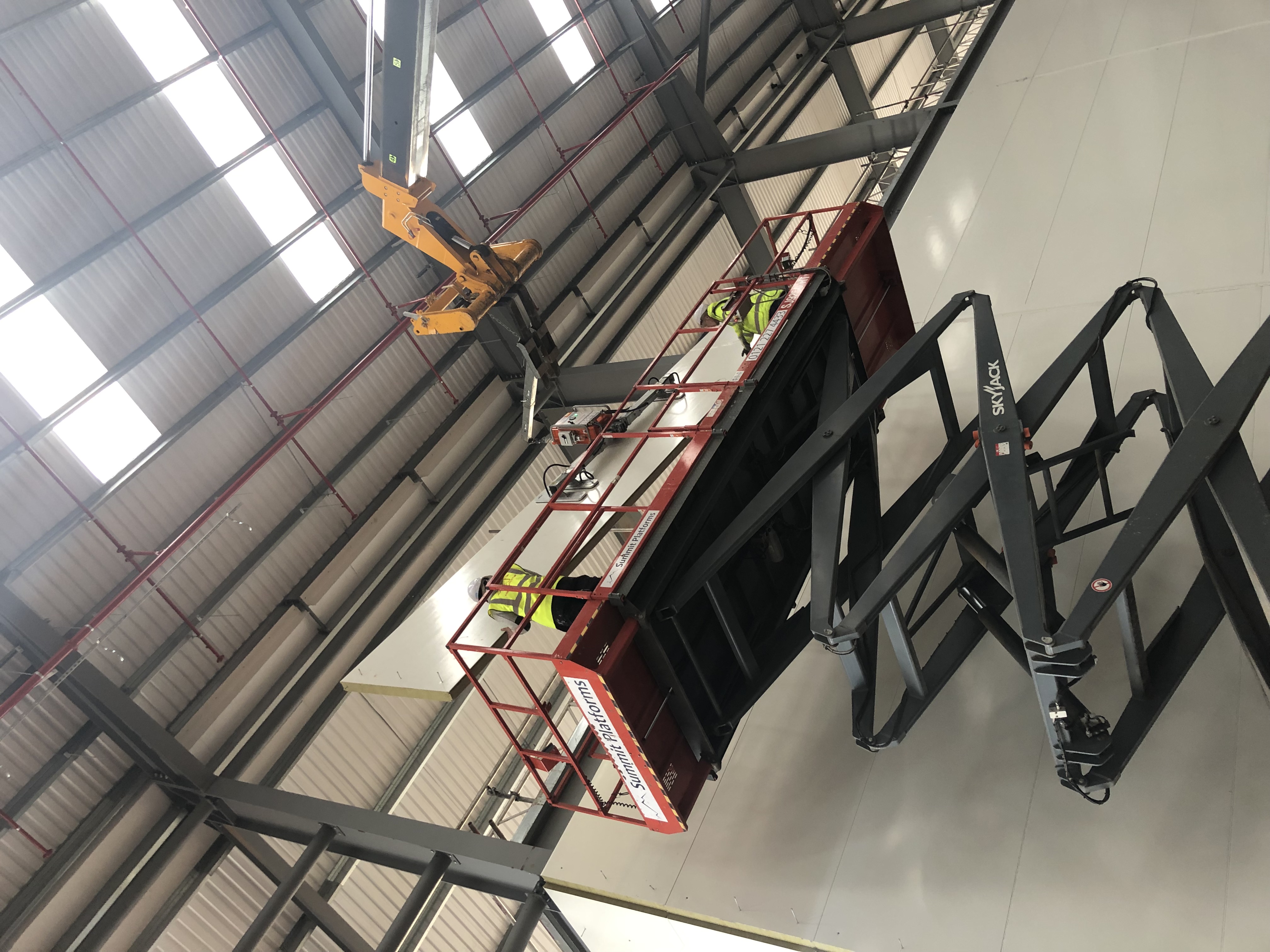 Scissor lift at height during fire-rated panel installation